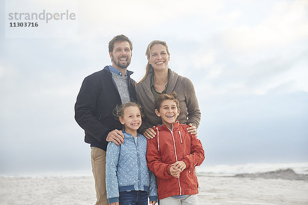 Porträt lächelnde Familie am Winterstrand