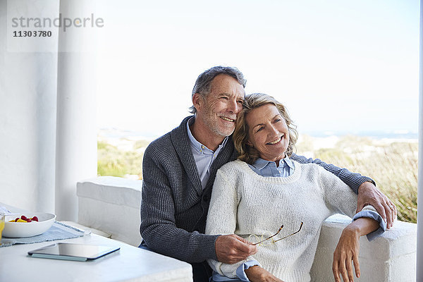 Lächelndes älteres Paar entspannt sich auf der Terrasse
