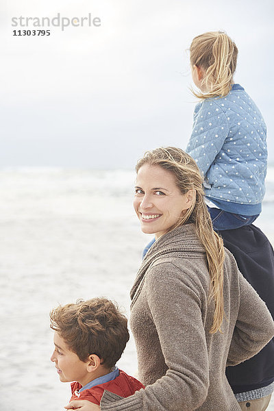 Porträt lächelnd Familie zu Fuß auf Winter Strand