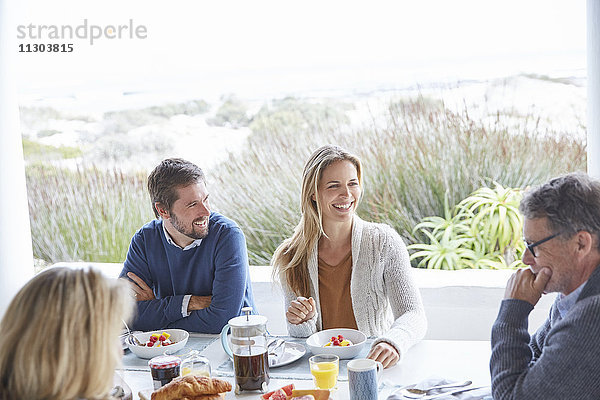 Paare genießen das Frühstück auf der Strandterrasse