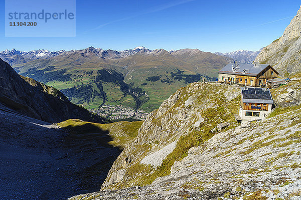 Die Lischana-Hütte SAC (Schweizer Alpen-Club) oberhalb von Scuol im Unterengadin  Schweiz. Blick hinunter zum Dorf Scuol und zu den Silvretta Alpen.