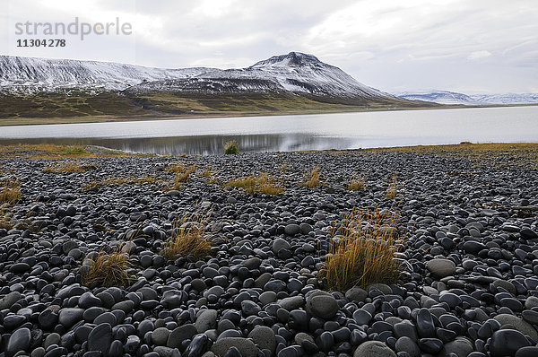 Auf dem Damm zwischen dem Festland (Hintergrund) und der Insel Pordarhöfdi im Fjord Skagafjördur im Norden Islands.