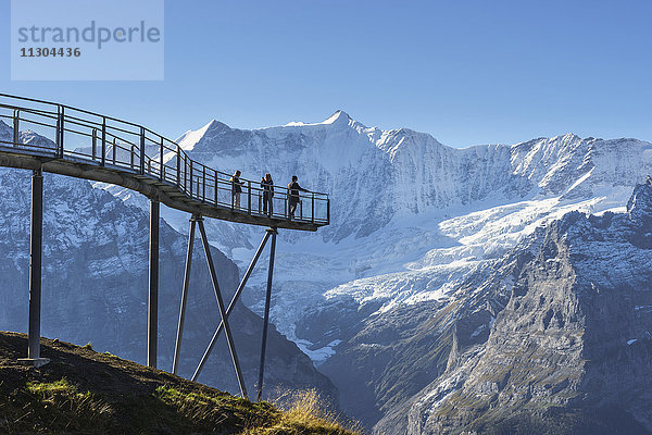Gipfelweg und Aussichtsplattform mit dem Namen First Cliff Walk auf dem Gipfel des First oberhalb von Grindelwald  Berner Oberland  Schweiz. Im Hintergrund die Berge Kleines Fiescherhorn (links) und Grosses Fiescherhorn.