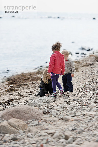 Mädchen und Junge spielen am Strand