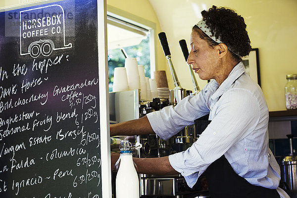 Frau  die in einem mobilen Café steht.