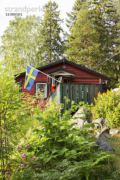 Holzhaus mit schwedischer Flagge