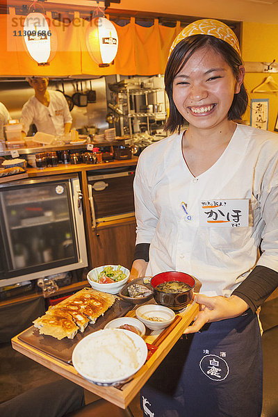 Japan  Honshu  Tokio  Restaurant Kellnerin serviert Essen