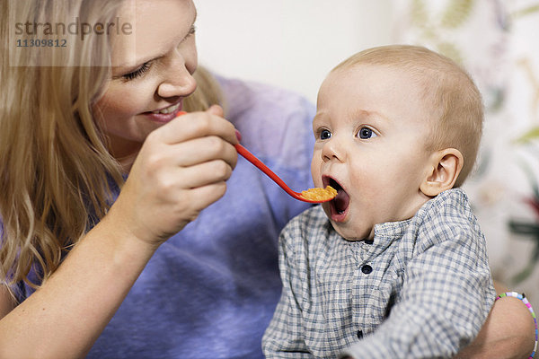 Mutter füttert kleinen Jungen