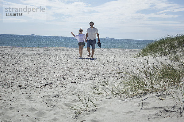 Junges Paar geht am Strand spazieren
