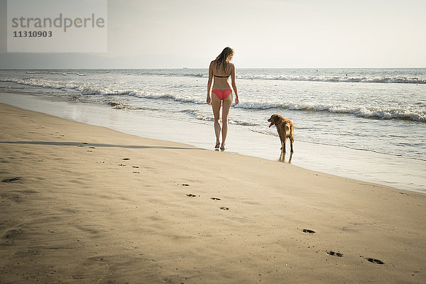 Mexiko  Riviera Nayarit  Frau beim Spaziergang mit Hund am Strand
