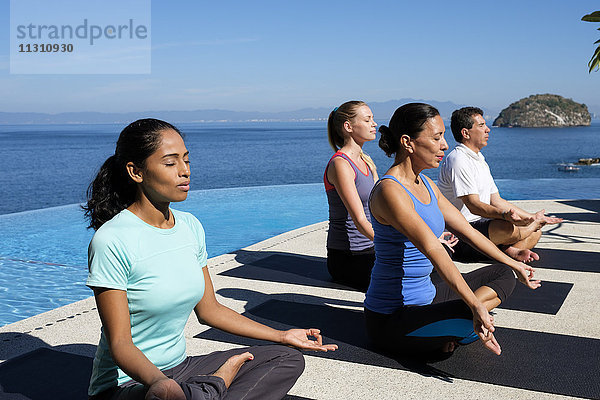 Yogagruppe beim Training am Meer