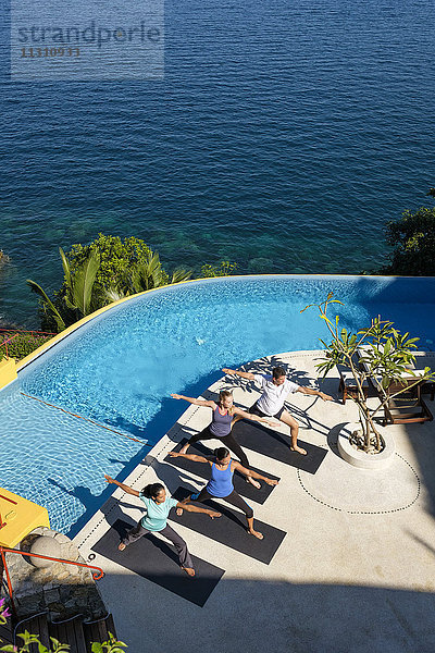 Blick von oben auf die Yogagruppe auf das Grundstück am Meer