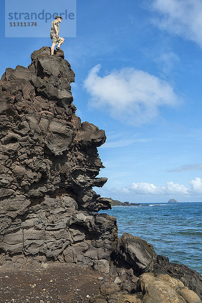 USA  Hawaii  Molokai  Mann auf Felsen an der Südküste MR