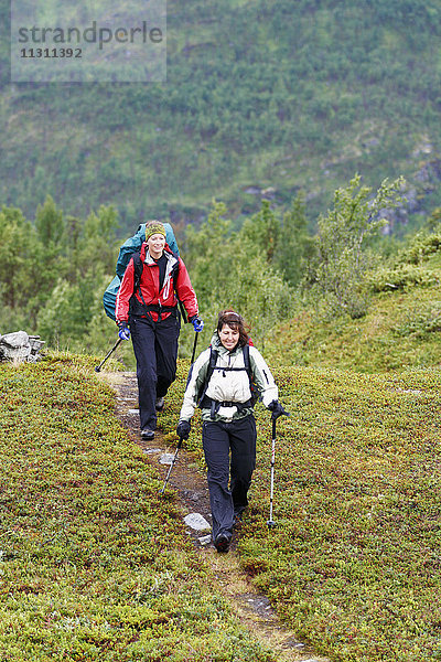 Weibliche Rucksacktouristen beim gemeinsamen Wandern