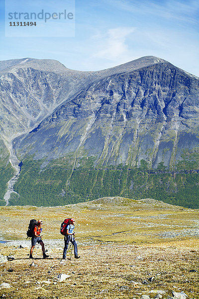 Weibliche Rucksacktouristen beim Wandern in der Landschaft