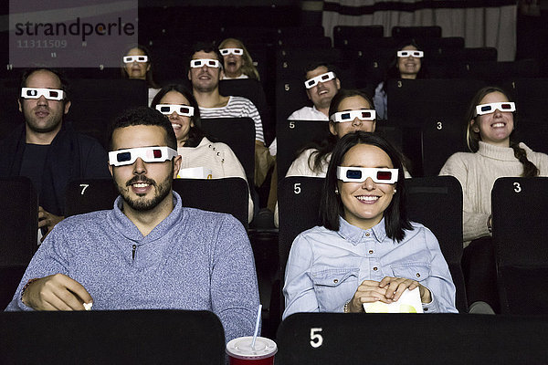 Leute mit 3D-Gläsern  die sich einen Film im Kino anschauen.