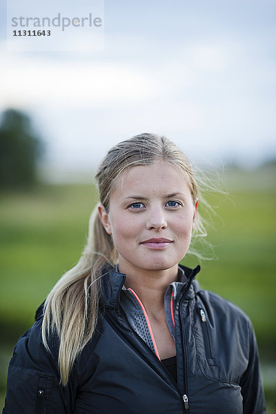 Porträt einer lächelnden jungen Frau auf einem Feld