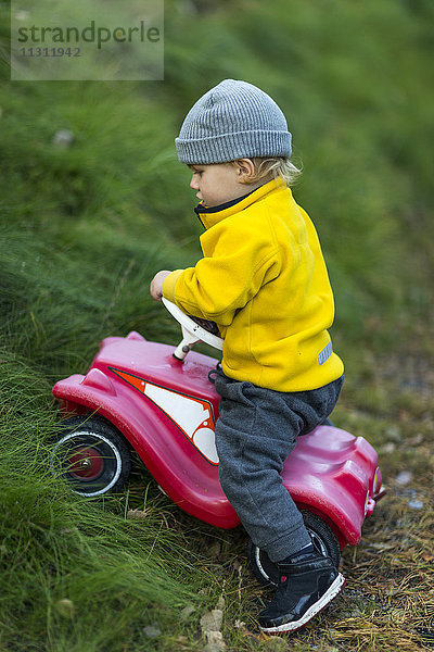 Junge auf Spielzeugauto