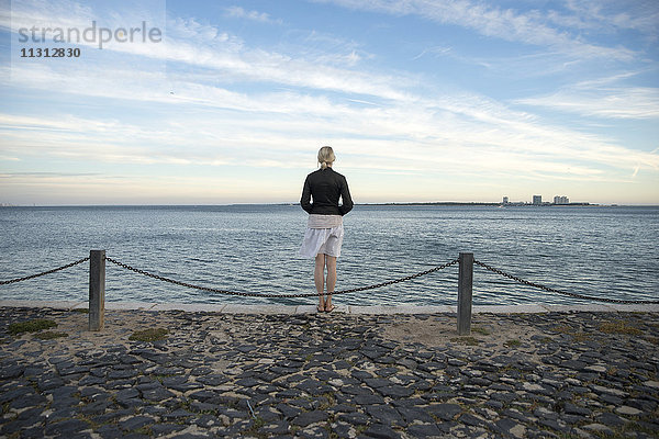 Portugal  Setubal  Frau am Meer stehend mit Blick auf die Halbinsel Troia