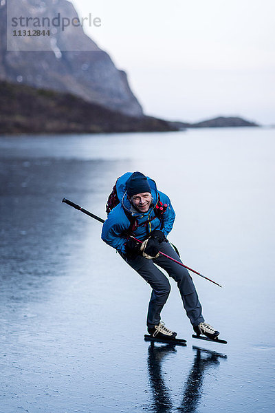 Porträt eines Mannes beim Schlittschuhlaufen auf einem zugefrorenen See