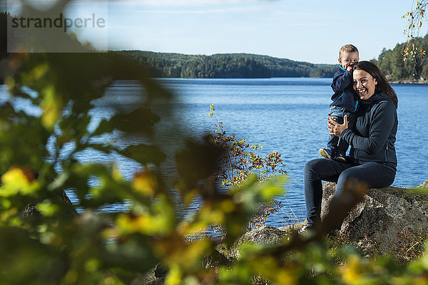 Mutter und Sohn sitzen am See
