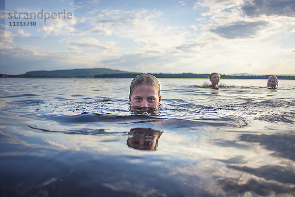 Vater und Kinder schwimmen im See