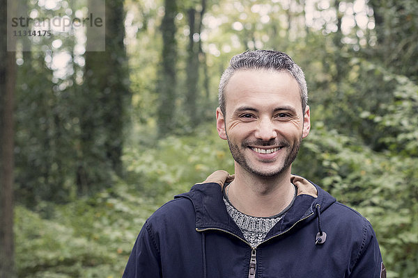 Porträt eines lächelnden Mannes im Wald