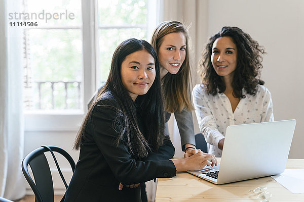 Drei Geschäftsfrauen arbeiten gemeinsam am Laptop