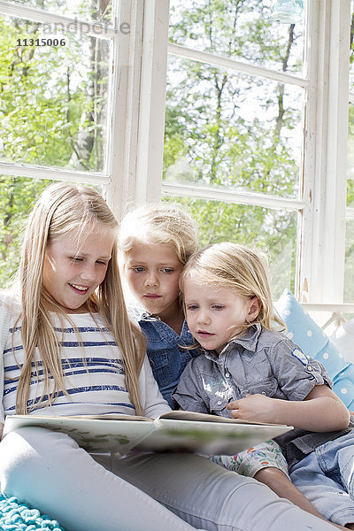 Drei Mädchen lesen ein Buch