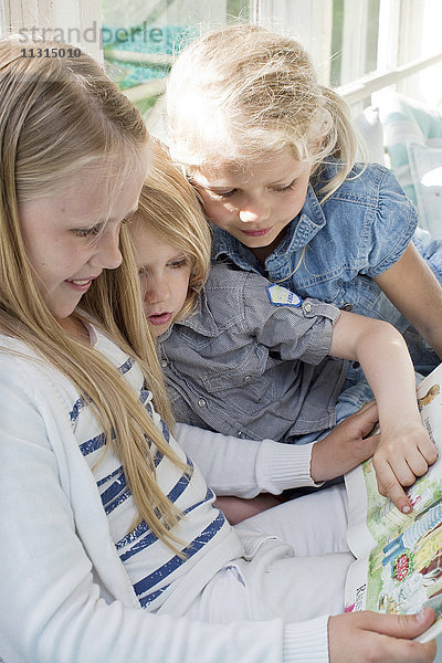 Drei Mädchen lesen ein Buch