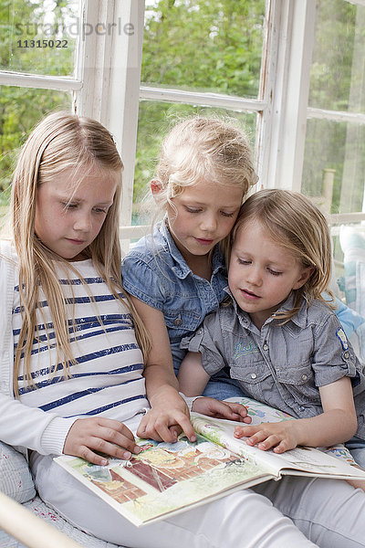 Drei Mädchen lesen ein Buch