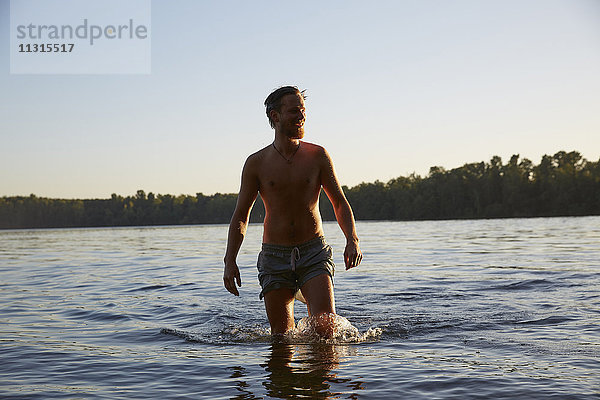 Glücklicher junger Mann in einem See
