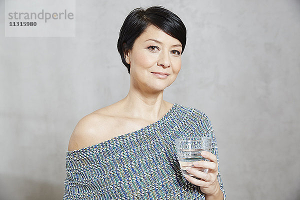 Porträt einer selbstbewussten Frau mit Wasserglas