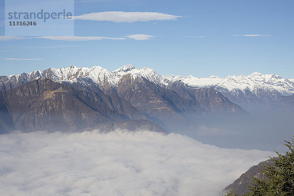 Nebelmeer und schneebedeckter Berg an einem sonnigen Tag im Tessin  Schweiz.