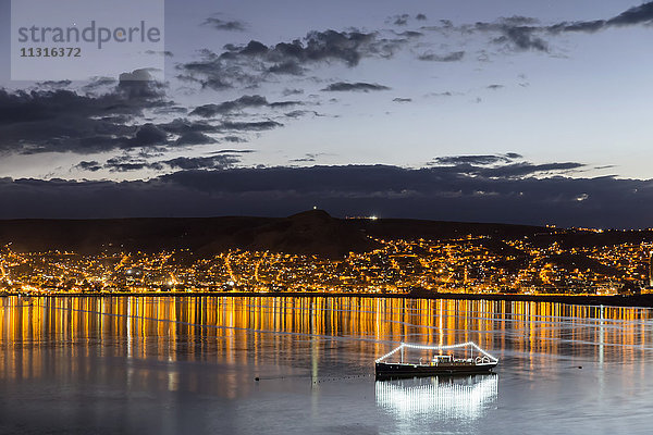 Peru  Titicacasee  Schiff und Stadtbild von Puno nach Sonnenuntergang