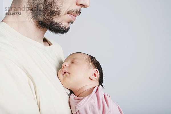Vater hält schlafendes Neugeborenes Mädchen in der Hand