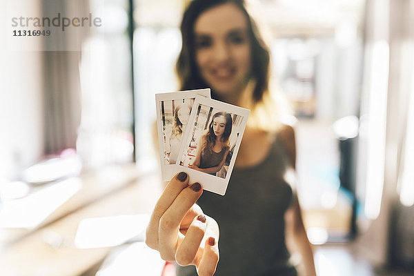 Junge Frau mit Polaroids von sich selbst
