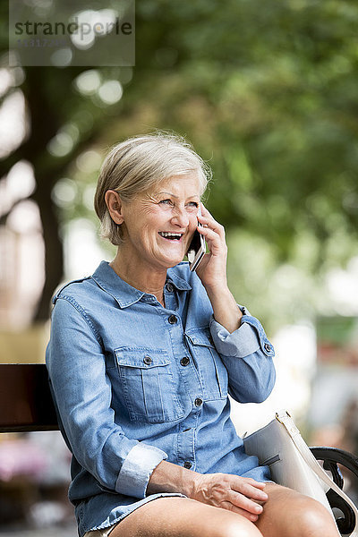 Porträt der lachenden Seniorin am Telefon