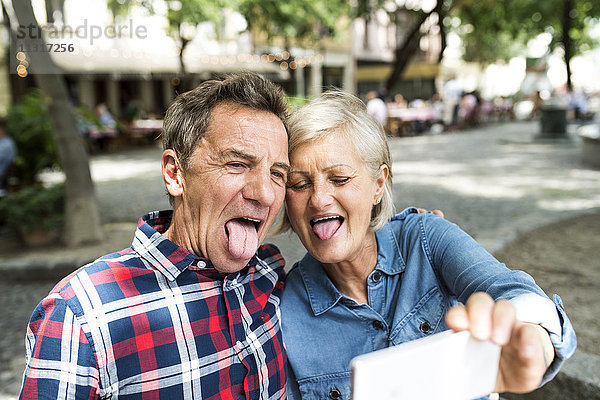 Senior Paar zieht lustige Gesichter  während sie Selfie mit dem Smartphone nehmen.