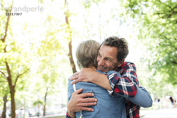 Seniorenpaar umarmt sich auf der Straße