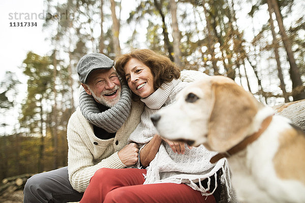 Glückliches Seniorenpaar mit Hund in der Natur