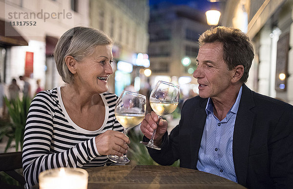 Seniorenpaar trinkt Wein an einer Bar im Freien