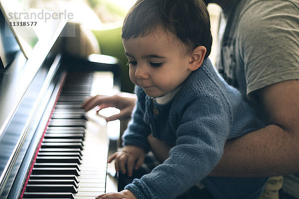 Kind und Vater beim Klavierspielen