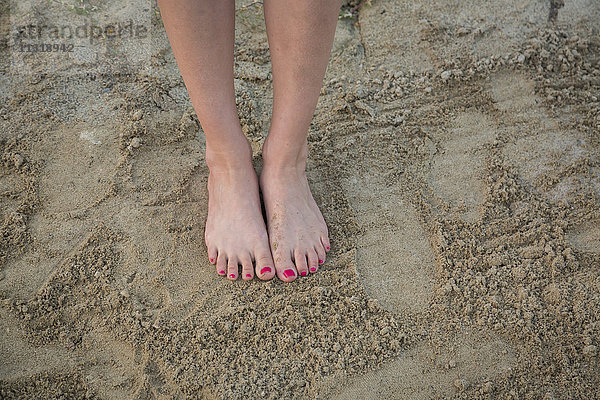 Frauenfüße auf Sand