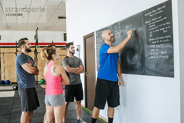 Trainer in einem Fitness-Kurs mit Tafelschreiben