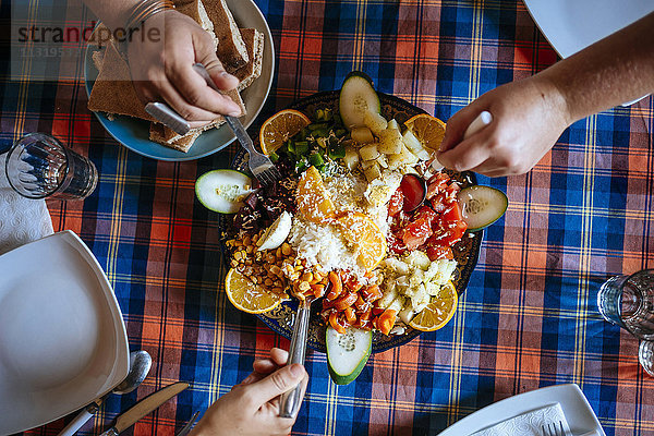 Drei Personen essen gemeinsam marokkanischen Salat  Teilansicht
