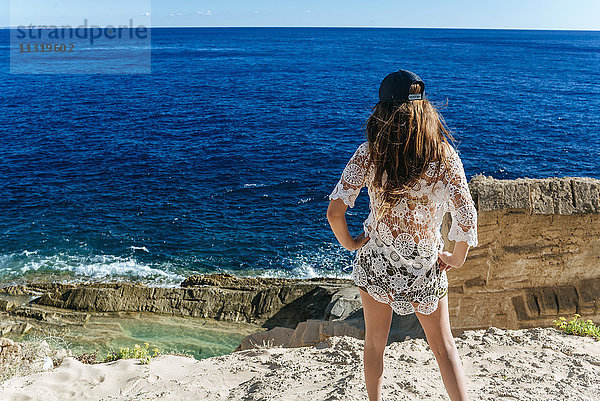 Spanien  Ibiza  Frau am Strand stehend  Blick aufs Meer