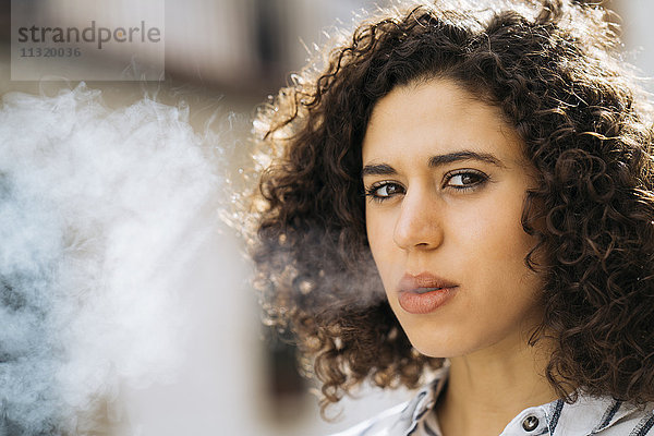 Porträt der rauchenden jungen Frau