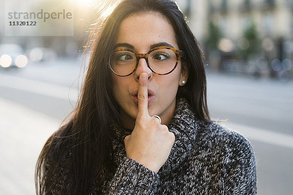 Porträt einer jungen Frau mit Brille  die Gesichter zieht