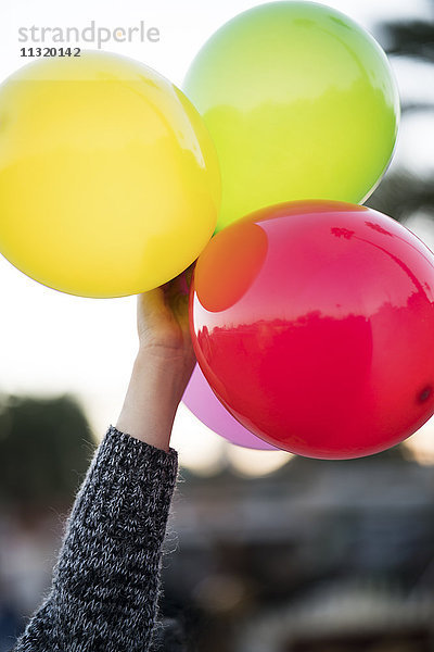 Frau hält Luftballons im Freien